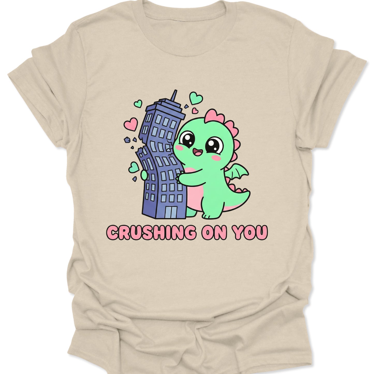 Natural unisex adult t-shirt featuring adorable green dinosaur crushing a city building in a loving hug.