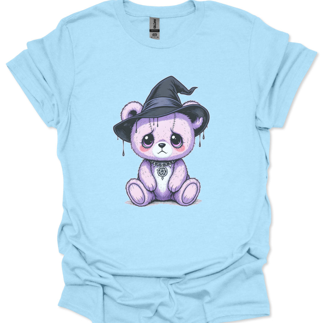 Light blue t-shirt with a cartoon bear wearing a witch hat on a white background