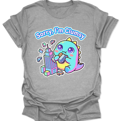 Sport Grey unisex t-shirt featuring a pastel chibi kaiju eating a bus with "Sorry, I'm Clumsy" text in bubbly letters.