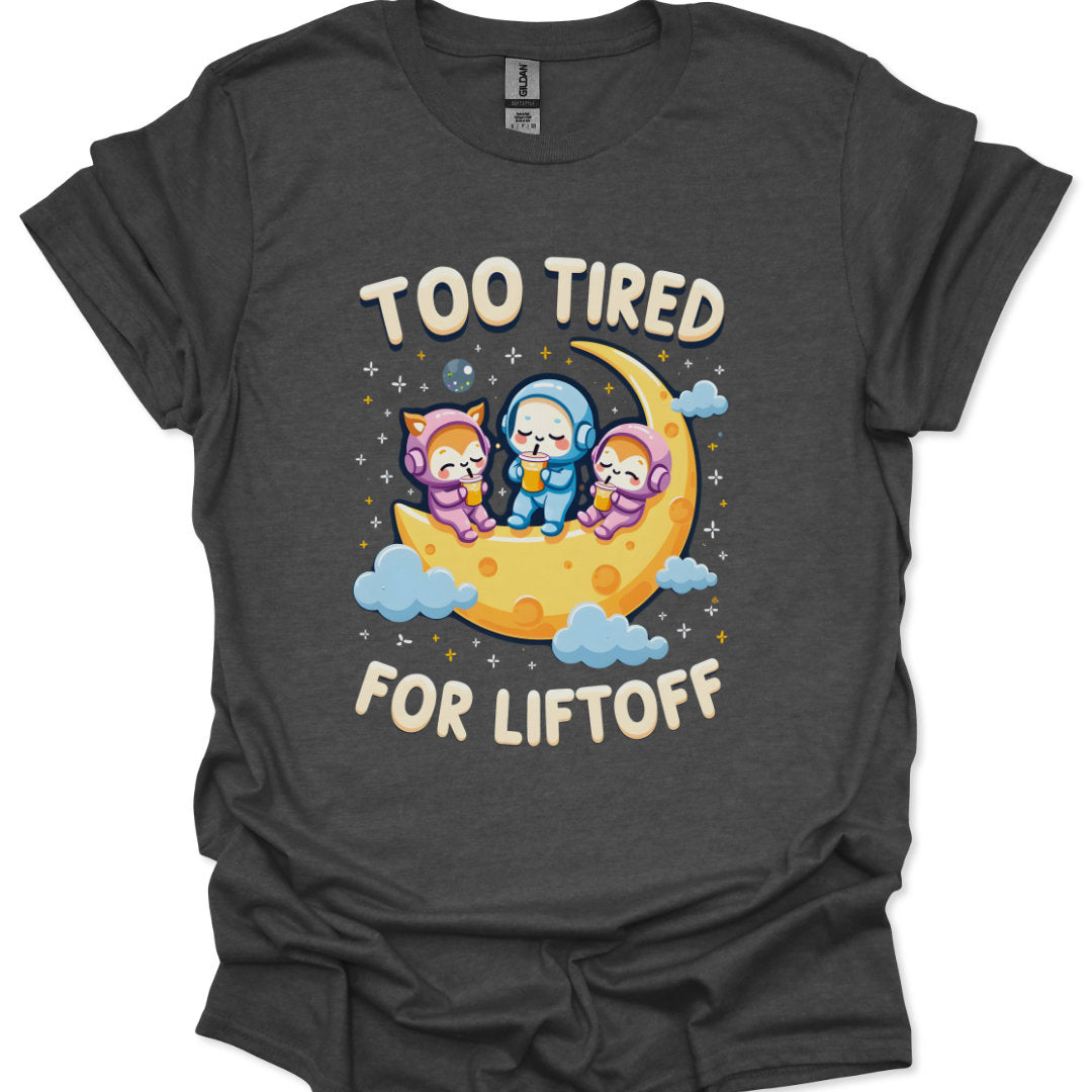 Dark gray t-shirt with cartoon characters on a moon and 'Too Tired for Liftoff' text.