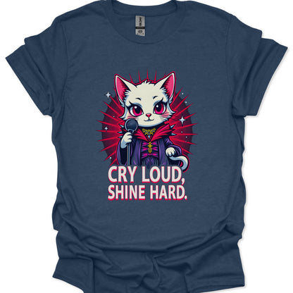 Navy blue t-shirt with a graphic of a cat in a robe and microphone, and text 'Cry Loud, Shine Hard' on a white background.