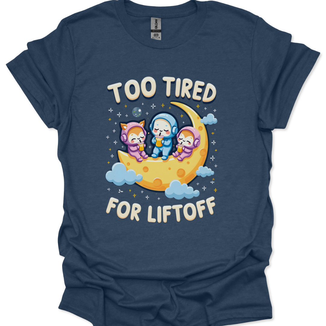 Navy blue t-shirt with cartoon characters on a moon and 'Too Tired for Liftoff' text.