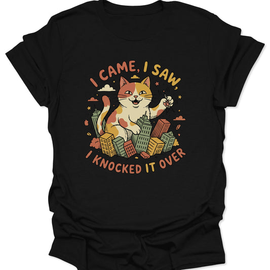 Black unisex adult t-shirt featuring a giant calico cat monster knocking over colorful city skyscrapers in a retro style.