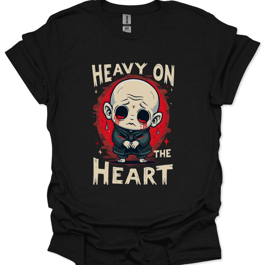 Black t-shirt with a graphic design of a character and text 'Heavy on the Heart' on a white background.