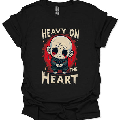 Black t-shirt with a graphic design of a character and text 'Heavy on the Heart' on a white background.