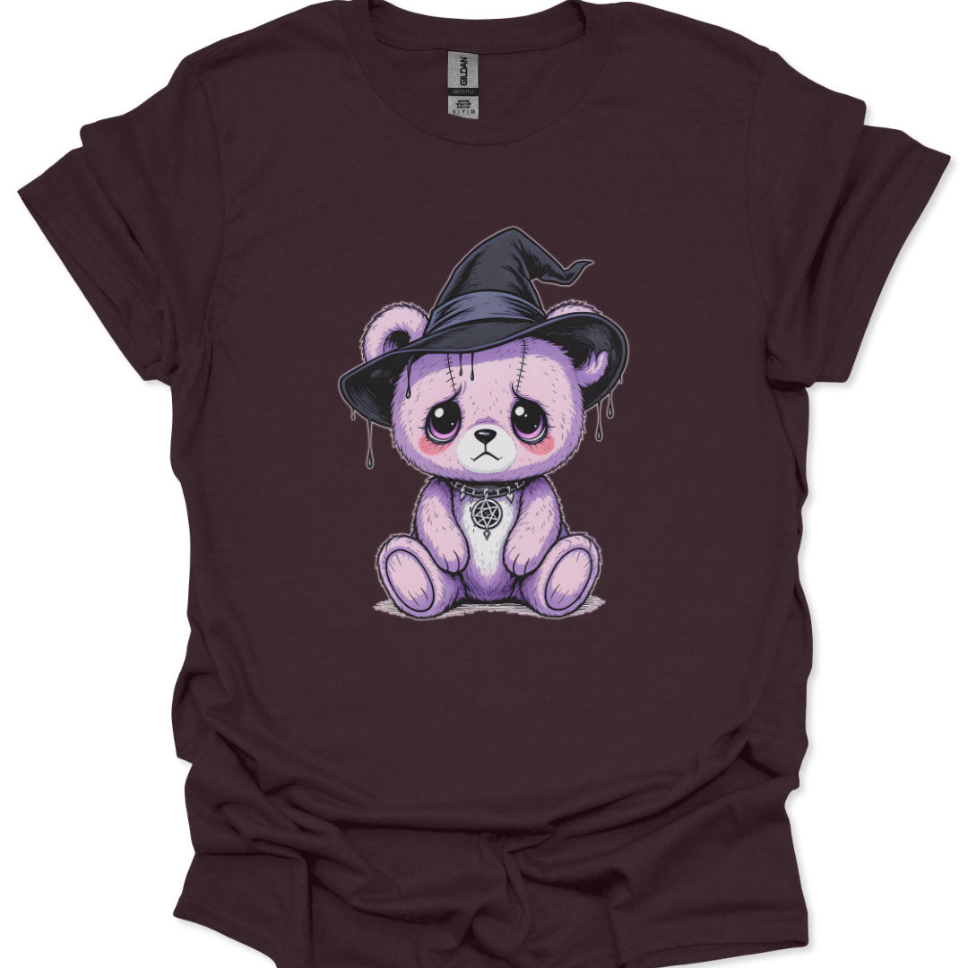 Maroon t-shirt with a cartoon bear wearing a witch hat on a white background