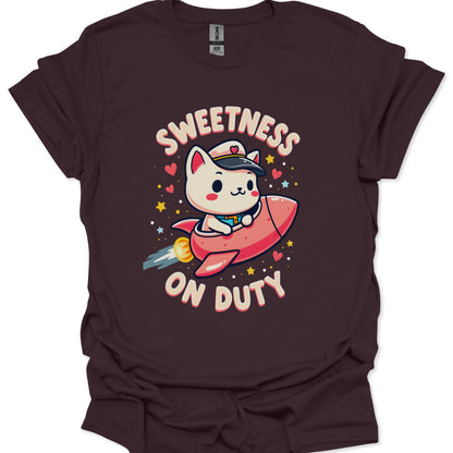 Brown t-shirt with a cartoon cat in a rocket ship and 'Sweetness on Duty' text.