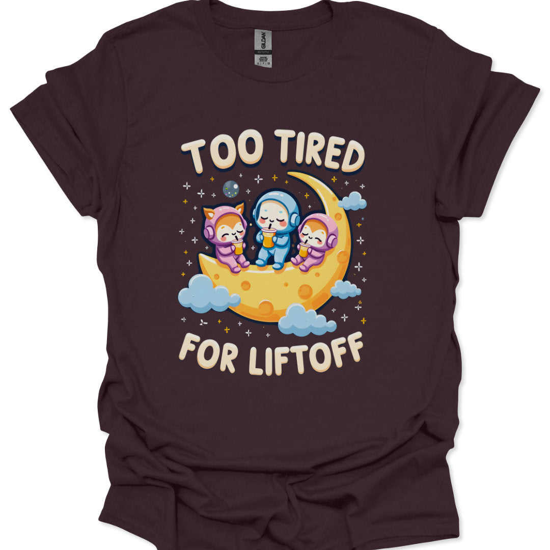 Brown t-shirt with cartoon characters on a moon and 'Too Tired for Liftoff' text.