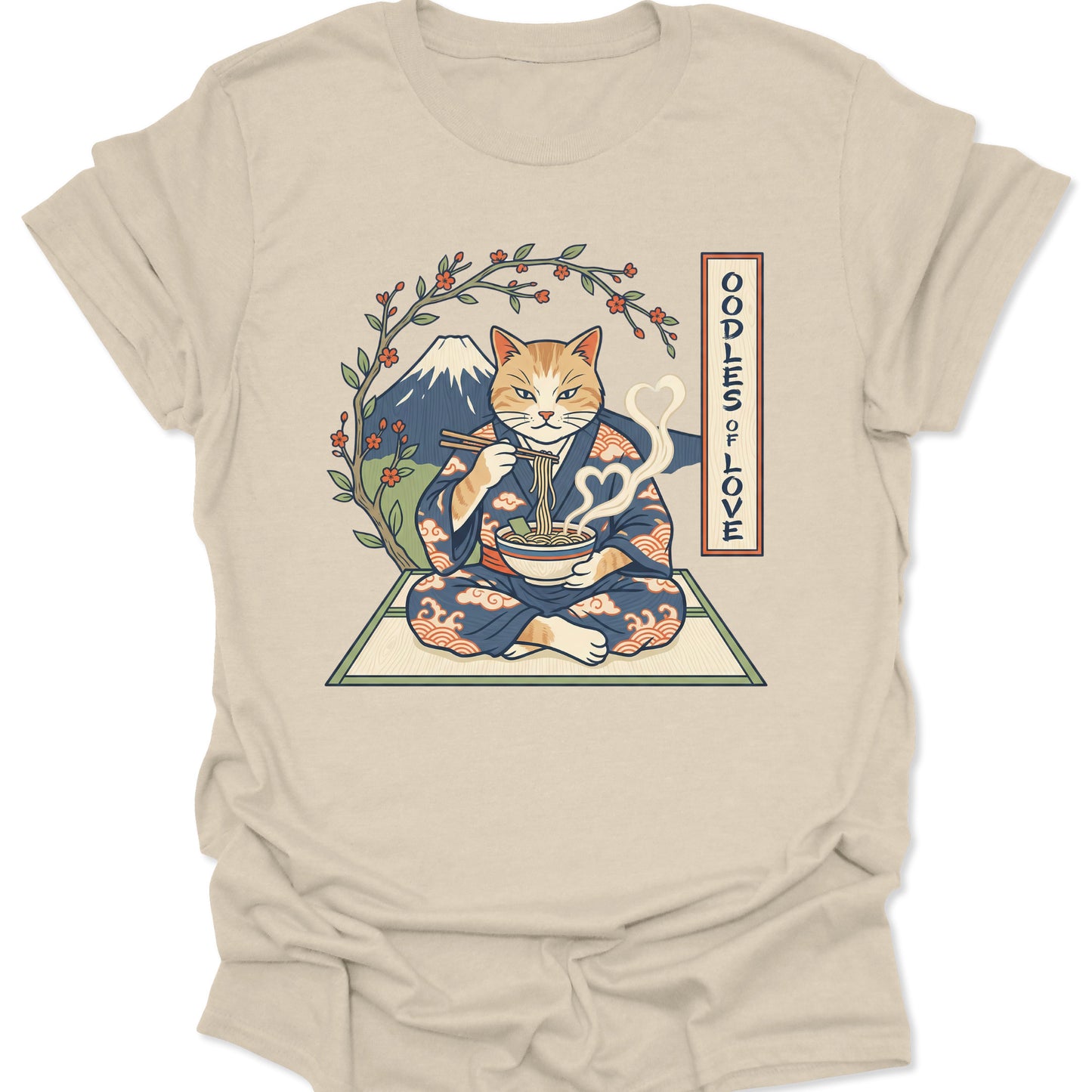 Natural unisex adult t-shirt featuring a kawaii cat in a blue wave kimono slurping noodles under a blooming sakura tree.