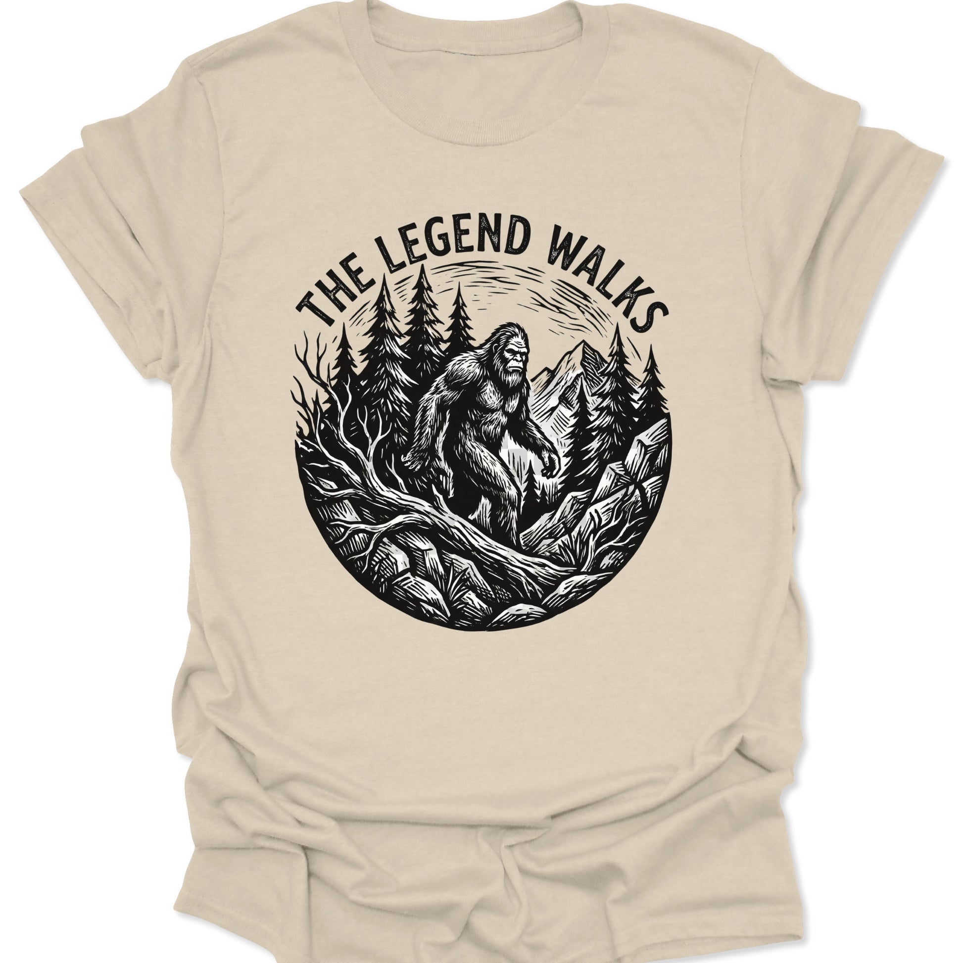 Natural unisex adult t-shirt featuring a hand-drawn legend walks cryptid design with tall evergreen trees and peaks.