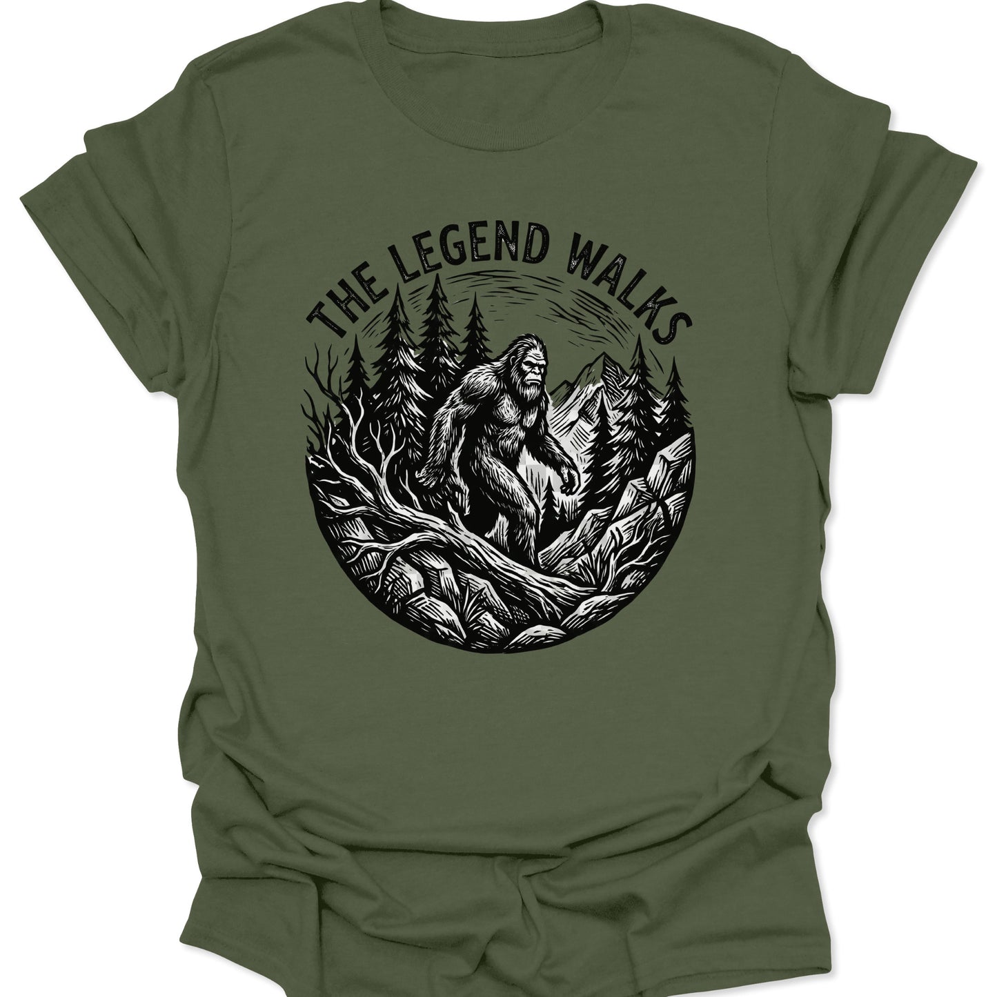 Military Green unisex adult t-shirt featuring a rugged Sasquatch hiking graphic in a high-contrast mountain landscape.