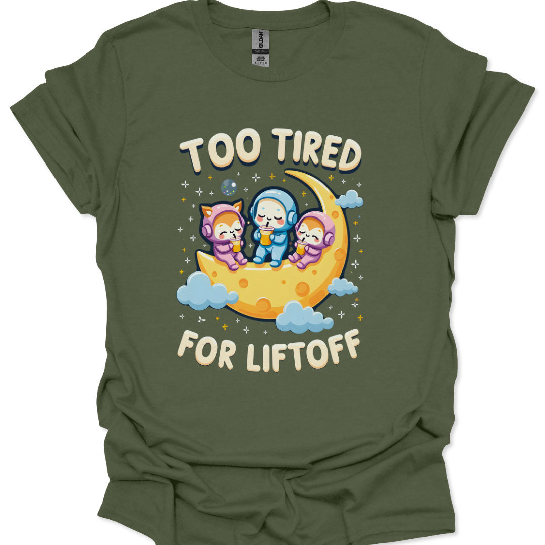 Green t-shirt with cartoon characters on a moon and 'Too Tired for Liftoff' text