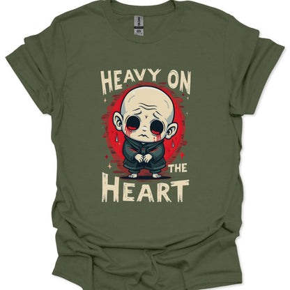 Green t-shirt with a graphic design of a character and text 'Heavy on the Heart' on a white background