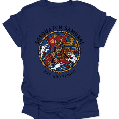 Navy unisex adult t-shirt with a bold Sasquatch Samurai graphic, crashing waves, and red maple leaves in Irezumi style.