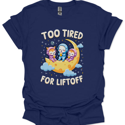 Navy blue t-shirt with cartoon characters on a moon and 'Too Tired for Liftoff' text.